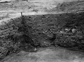 Excavated section face showing layers of soil and stones at the large water channel, Ayia Irini.