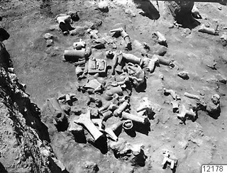 Excavation at Ayia Irini with many broken sculpture fragments and vessel pieces lying in situ on the ground.