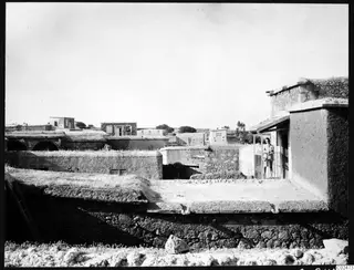 Flat-roofed stone houses of Ayia Irini village, with Erik Sjöqvist standing on a balcony at the right