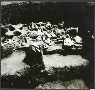 Pottery vessels and sherds lying in situ in an excavation trench at Ayia Irini