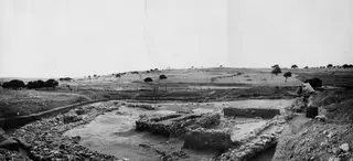 Excavated temenos at Ayia Irini seen from the south-east, with stone foundation walls and a tent at the right edge.