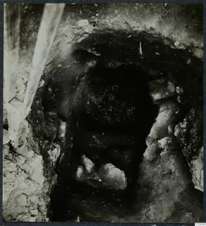 Tomb 9 at Enkomi: dark tomb chamber opening with stones, seen during excavation