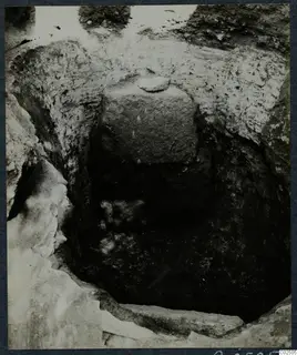 Tomb 6 at Enkomi during excavation, looking down into the tomb chamber past a large stone block