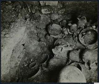 Tomb 13 at Enkomi during excavation, with pottery vessels and bones lying in the tomb chamber
