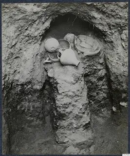 Pottery vessels lying in situ in an excavated niche at Ayios Iakovos