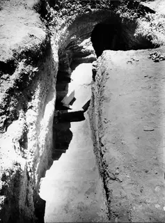 Dromos leading up to the arched entrance of Tomb 61 at Marion, with stone slabs in the sloping passage.