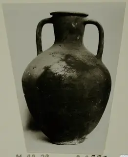 Two-handled amphora with a narrow neck and rounded body, shown in a mounted photograph