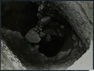 Tomb 18 at Enkomi: a dark opening with fallen stones, seen from above during excavation