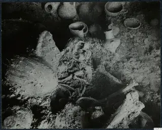 Tomb chamber at Enkomi with a skeleton and pottery vessels during excavation