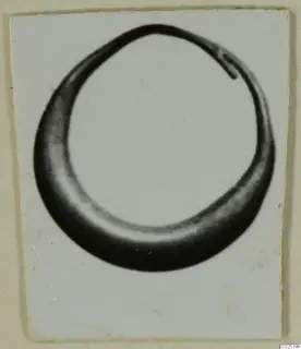 Ring from Enkomi, shown in a photograph mounted on a white card.