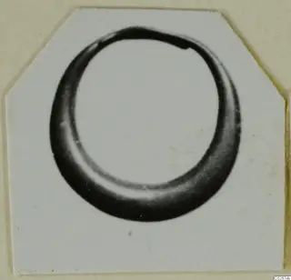 Single gold ring from Enkomi, shown in a close photograph on a card mount