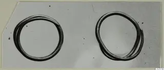 Two thin wire hair-rings photographed side by side against a grey background.