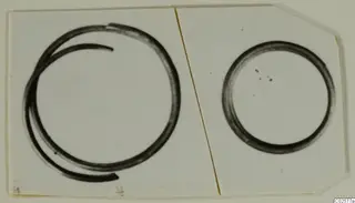 Two rings on a pale card: a larger open coil with overlapping ends and a smaller plain closed ring