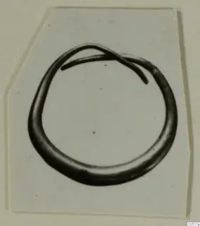 Earring from Enkomi: an open loop of dark metal with one tapering end overlapping the other.