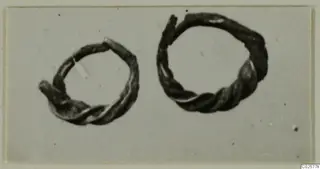 Two twisted wire earrings from Enkomi, dark and tarnished, shown side by side