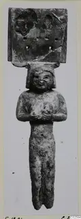 Bone figure from Enkomi: a small standing figure with arms folded across the chest and a plaque with holes above the head