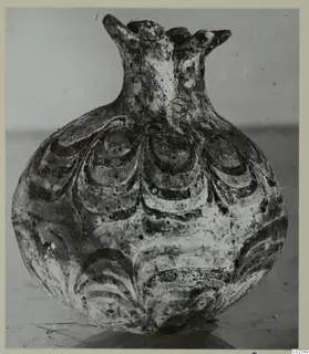 Round vessel with a short flared neck, lobed rim projections and overlapping curved bands of decoration on the body