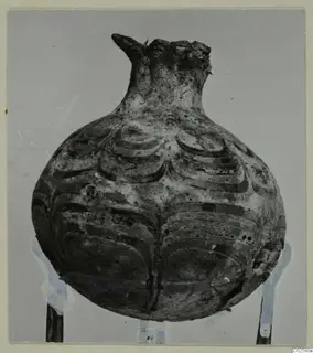 Rounded vessel with a narrow neck and symmetrical curved painted bands, photographed from Enkomi.