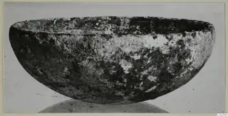 Deep bowl with thick walls and a mottled, weathered surface, from Enkomi small finds.