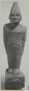Limestone Cypro-Egyptian statue of a standing figure with a tall conical head covering.