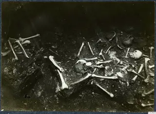 Tomb 6 at Enkomi during excavation, with scattered skeletal remains and small finds in the tomb chamber