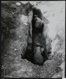 Tomb 422 at Lapithos Kastros during excavation: a narrow cut with large stone slabs and a tomb chamber opening