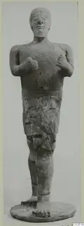Terracotta standing figure with raised fists and a short skirt, Proto-Cypriote I, shown full length