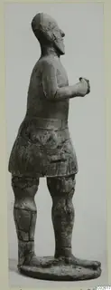Standing terracotta figure in profile from Ayia Irini, arms bent with hands at the chest