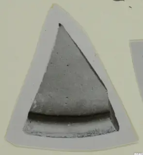 Triangular sherd, photographed in grey tones on a pale card mount.