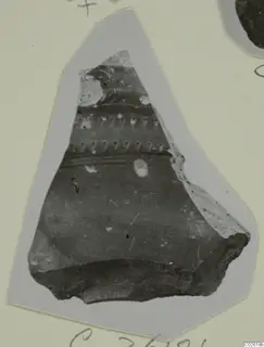 Pottery sherd with two rows of small impressed marks and horizontal grooves, shown on a grey card mount