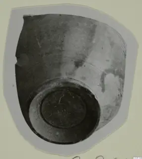 Red Lustr II vessel seen at a steep angle, showing its ring base, mounted on a card