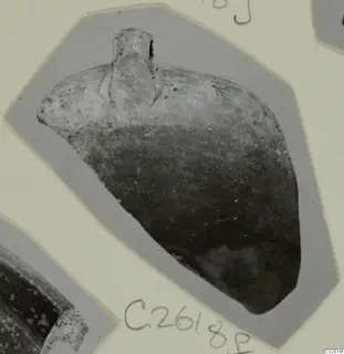 Pottery sherd with a short upright projection at the top, photographed on a grey card mount