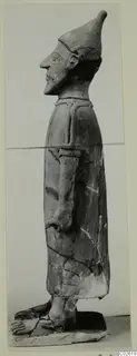 Terracotta Proto-Cypriote I: standing figure in profile, facing left, with a tall pointed cap and long garment