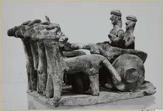 Terracotta model of a wheeled vehicle drawn by a row of animals, with two seated figures, from Ayia Irini