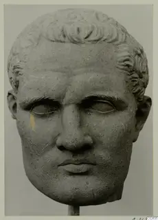 Stone sculpture head of a man with short curled hair, mounted on a stand