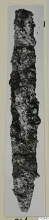 Long, narrow, heavily corroded object tapering to a point, shown upright on a mounted card, from Marion