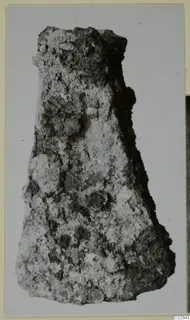 Heavily corroded iron tool from Marion, tapering and crusted with rust, photographed against a grey backdrop