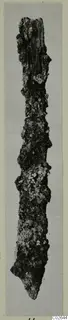 Heavily corroded metal tool from Marion, long and narrow with a pointed end, on a grey mount.