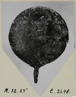 Bronze toilet requisite: a round disc with a short stem, corroded, photographed on a mounted card