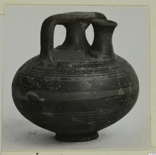 Pottery bowl-jar from Ayios Iakovos with a strap handle and two necks, dark surface with horizontal bands