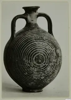 Two-handled vessel with a rounded body and concentric ring decoration, photographed against a plain grey background