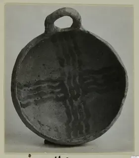Round shallow vessel with a loop handle at the rim, its interior decorated with wavy dark painted bands