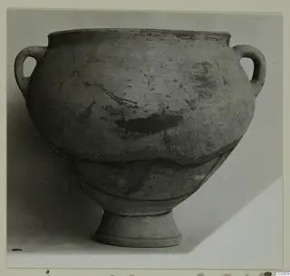 Plain white wheel-made pottery jar with two loop handles and a ring foot