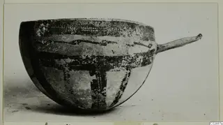 White Slip Ware bowl with a long handle and dark painted bands on a pale body