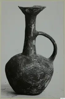 Jug of Black Slip Ware from Ayios Iakovos with a flaring rim, loop handle and incised chevron bands