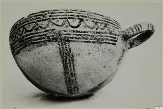 Pottery White Slip Ware bowl from Ayios Iakovos with a single loop handle and dark painted bands and arc motifs