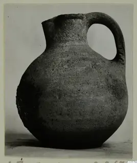 Jug with a rounded body and a single loop handle, from Ayios Iakovos, shown against a plain backdrop