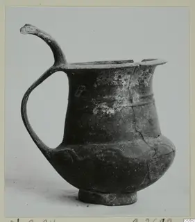 Pottery Base-Ring Ware jug with a tall loop handle and a ring base, shown against a plain background