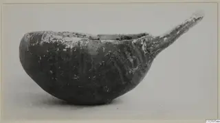 Pottery Red-on-Black etc bowl with a long tapering handle, seen from the side