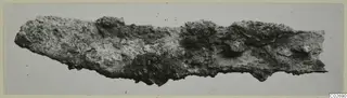 Corroded metal fragment from Marion, lying flat on a pale background